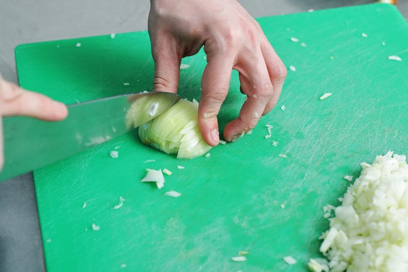 chef demonstrating how to cut up an onion