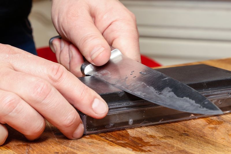 instructor showing how to sharpen a knife with a wet stone